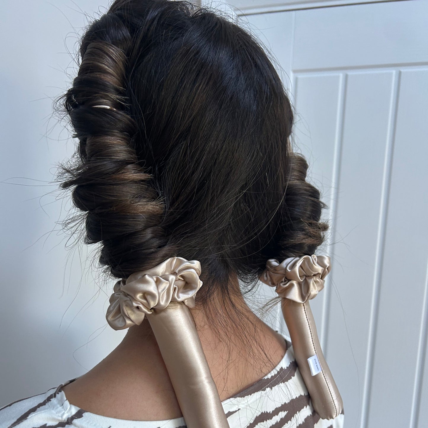 Model wearing the Haus Gio silk heatless curler in her hair, demonstrating how the curler wraps the hair gently to create soft, voluminous curls without heat.