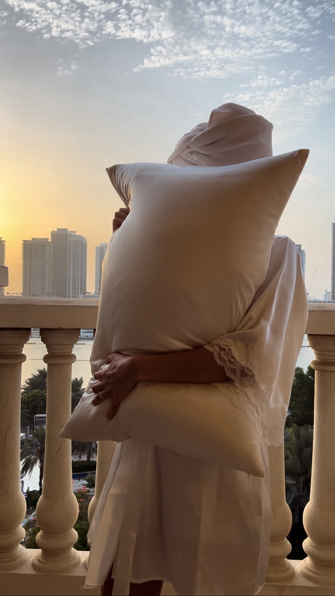 model hugging silk pillowcase Dubai sunset balcony